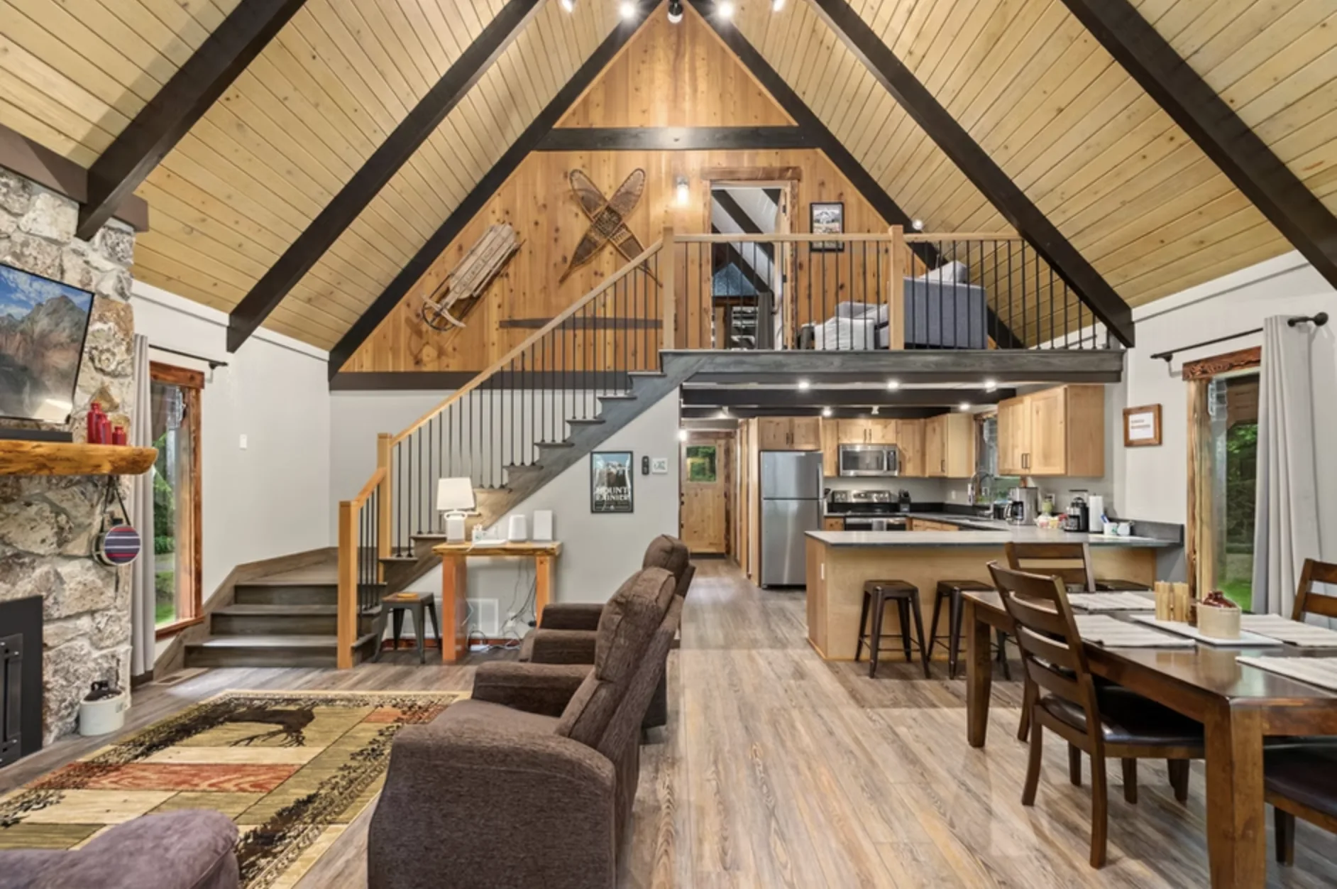 Stone fireplace great room at Redtail Rendezvous — luxury cabin in Washington State